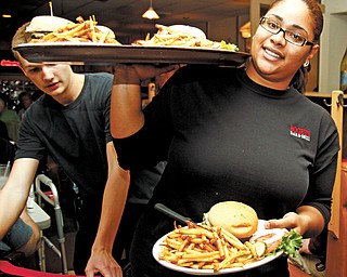 Kesha Rhodes, waitress at Bogey’s Bar & Grill, delivers meals to the Burger Guyz.