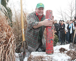 Raul Kemp, a teacher at Trumbull County Career and Technical Center, unearths a time capsule that was buried in
front of the school in 1988. Students and staff unearthed the capsule in a ceremony Thursday. One of the items inside it, inset below in story, was a senior awards program for the Trumbull County Joint Vocational School, TCTC’s original name.