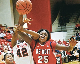 Detroit’s Yar Shayok (25) is elbowed in the face by Youngstown State’s Brandi Brown (42) as Brown takes a shot during the first half of their game Thursday at YSU’s Beeghly Center. The Penguins defeated Titans, 58-53.