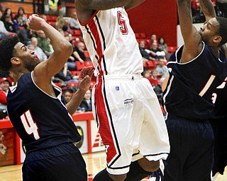 MADELYN P. HASTINGS | THE VINDICATOR
Youngstown State's Kamren Belin (5) takes a shot for the team while UIC's Gary Talton (4) and Daniel Barnes (1) defend during the second half of their game at the Beeghly Center on February 10, 2013. The Flames beat the Penguins 88-83 in triple overtime.