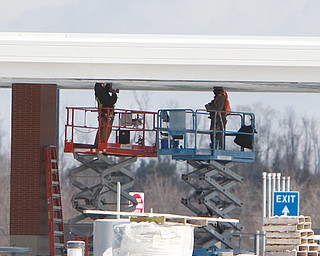 Crew members work on the ceiling of a fueling area at the Ohio Turnpike’s Glacier Hills service plaza in New Springfield. That plaza and the Mahoning Valley plaza should reopen before Memorial Day.