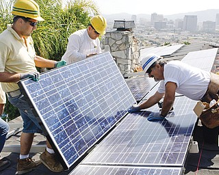 California Green Design employees assemble solar electrical panels on the roof of a home in Glendale, Calif. Homeowners on the hunt for sparkling solar panels are lured by ads filled with images of pristine landscapes and bright sunshine, and words about the technology’s benefits for the environment. However, the industry is creating millions of solar panels each year and, in the process, millions of pounds of polluted sludge and contaminated water.