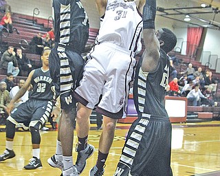 Boardman’s Austin Downie (31) tries to shoot over Warren Harding’s King Garner (14) and Greg Jackson (23) during a game Tuesday night. Harding won, 41-27.