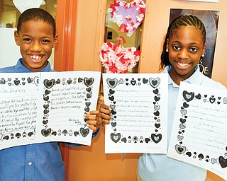 Tavan Sallie, left, and Kamille Moore, fourth graders at Youngstown’s Taft Elementary School, show off the valentines they wrote and sent to soldiers at the Department of Veterans of Affairs Medical Center in Pittsburgh’s
Post Traumatic Stress Disorder Clinic.
