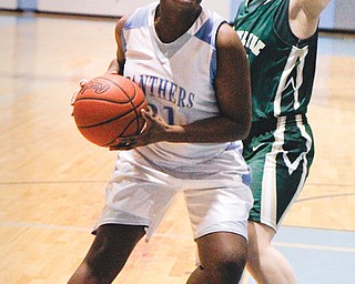 East’s Ashlyn Baker (21) makes a move to the basket against Ursuline defender Mary O’Donnell (15) during their basketball game Wednesday at East High School. The Irish defeated the Panthers, 52-44.