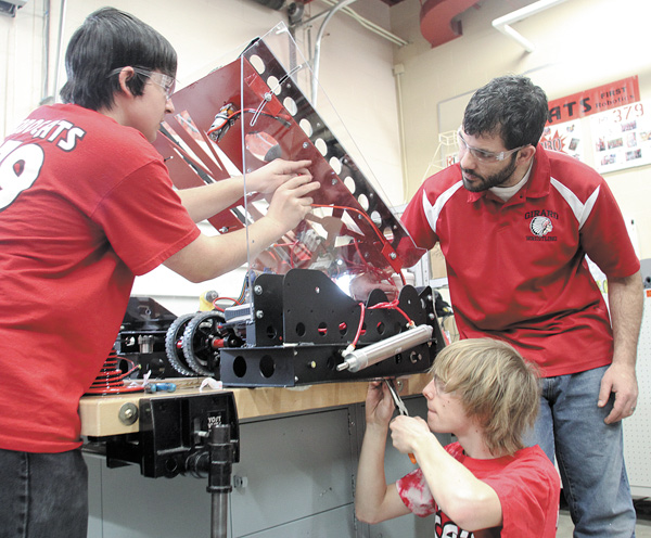 Austin Wagner, left, a sophomore at Girard High School, and senior Sam Horne, center, assemble parts for the RoboCats’ new robot under the supervision of Ashraf Hadi , team adviser. The school’s robotics team has been working for six weeks to build its new robot, which will compete beginning in March.