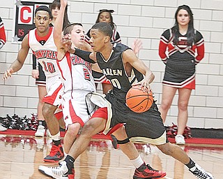 Canfield’s Cole Pryjma (2) draws the charge on Anthony Bell (30) of Warren Harding during their game Tuesday in Canfield. The Raiders edged the Cardinals, 61-58, on a 3-point buzzer beater by O’Sha Jackson.