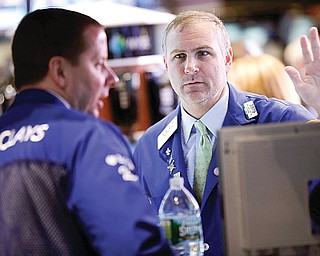 Traders work on the floor at the New York Stock Exchange in New York on Tuesday, when talk of more mergers and acquisitions sent stock prices higher.