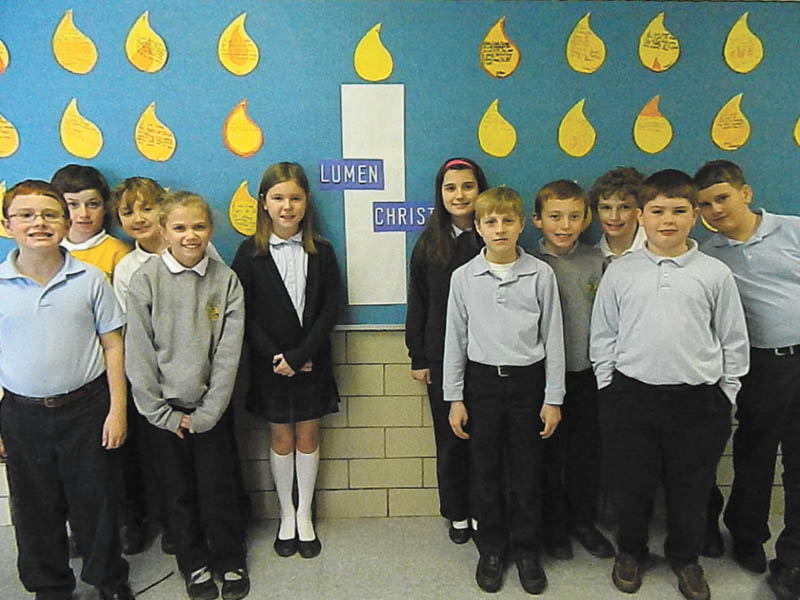 Fourth-grade students of Holy Family School are standing in front of the Lumen Christi bulletin board. They are, from left in front, Steven Hiner, Caitlin Palusak, Jacob Shogren and Patrick Assion; and, in back, Dominic DeToro, Patrick Howlett, Ava Szalay, Augusta Fox, Payton McMahon, Brian White and Matthew Ranno. The board was designed by fourth-grade teacher Kathy Holsinger to make students and families aware of Catholic identity and faith infused with learning. The new Lumen Christi Catholic School System includes Catholic elementary schools in the Mahoning Valley. In Latin, the name means Light of Christ and is put into practice through daily prayer, regular liturgy participation and the compassion students demonstrate through varied service projects.