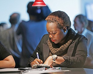 An unidentified woman answers questions on a job application at a job fair in Sunrise, Fla. The number of Americans seeking unemployment benefits jumped 20,000 last week to a seasonally adjusted 362,000, though it remains at a level that suggests slow but steady improvement in the job market.