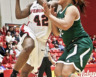 Youngstown State senior Brandi Brown (42) shoots against Cleveland State defender Nafeshia Holifield (32) during the first half of their game Thursday at YSU’s Beeghly Center. Brown scored a season-high 33 points and grabbed 11 rebounds to help lift the Penguins over the Vikings, 73-69.