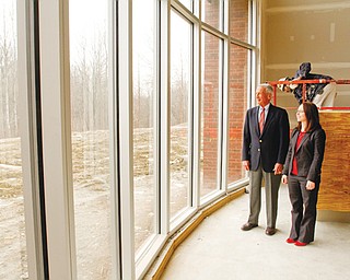Dr. David Ritchie, president of the board of trustees of the Public Library of Youngstown and Mahoning County, tours the new Jackson-Milton public library under construction on Mahoning Avenue in Jackson Township. With him is Heidi Daniel, director of the library system.