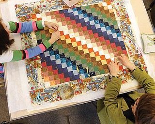 Linda Spencer, left, and Sherry Ziegler, members of Bethel Lutheran Church Piecemakers, work on a small-square
rainbow colored quilt during a gathering Tuesday at the church in Boardman.