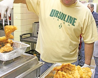 Alex Forte of St. Patrick Church in Hubbard takes deep-fried haddock out of the fryer during a fish fry at the church on a recent Friday. Volunteers prepare days in advance for a meal attended by more than 600 people
on Fridays during Lent.
