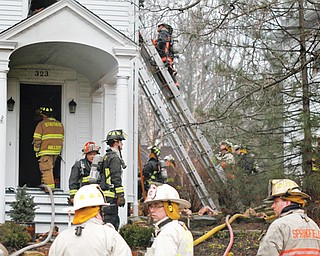 Firefighters work on a house fire at 323 S. Main Street in Poland on Thursday afternoon. The house, built in 1834, was being renovated at the time of the fire. Two dogs inside the home died, but homeowners were not in the house when the fire broke out.