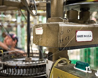 A machine affixed with a “Made in the U.S.A.” plate is seen at the FesslerUSA apparel manufacturing plant in Orwigsburg, Pa. The U.S. economy grew at a 0.1 percent annual rate from October through December, the weakest performance in nearly two years, according to the Commerce Department’s latest calculations, released Thursday. But economists believe a steady housing rebound and solid spending by consumers and businesses are pushing growth higher in the current quarter.