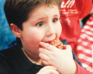 Albert Pacella, 7, of Canfield, takes a bite of his favorite buff alo-chicken pizza from Cocca’s Pizza at the 2013 Mahoning Valley Pizza Cook-Off at Mr. Anthony’s in Boardman. The cook-off , in its fourth year, is a fundraiser for the Potential Development Program, Inc., which serves autistic children.