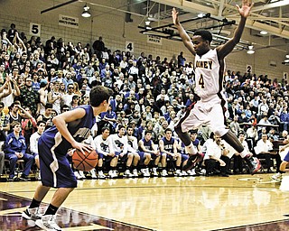 Cardinal Mooney’s George LeFlore (4) leaves his feet to try to prevent Poland’s Nick Gajdos from inbounding the ball during a Division II district semifinal Monday night at Boardman High School. Cardinal Mooney beat top-seeded Poland, 51-33.