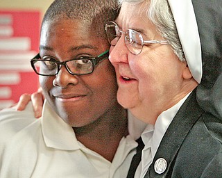 Sister Mary Dunn, principal of Youngstown Community School, gives a congratulatory hug to Demar Brown after the student performed well on a test.