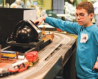 Brett Seybert, 10, of Fowler controls a model train on display during the Youngstown Model Railroad Association flea market at McMenamy’s in Niles on Sunday. The youngster operated two model trains around a display built by the Western Reserve Model Railroad Club that depicts parts of Youngstown from days gone by.