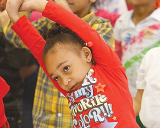 Isabella Torres, a kindergartner, stretches before participating in the strenuous exercise of the Radio Disney Dance Party at her school.