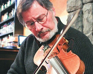 Krygowski, of Poland, plays a tune on his fiddle. He also plays a six-holed woodwind instrument called a penny whistle. He says, “Sharing tunes is just a beautiful social event.”