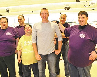 Tommy Warg, center, stands with some of the members of the Purple Cat men’s bowling league recently at Camelot Lanes in Boardman. Photo by William D. Lewis | The Vindicator