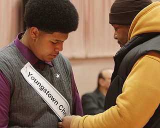 ROBERT  K.  YOSAY  | THE VINDICATOR --..Tavares Hodge  7th grader from Youngstown Christian school  gets his banner pinned on by his dad  Elliot as the BEE got underway ......The 80th  Youngstown Vindicator Spelling Bee was held at Kilcawley Center on YSU Campus  Saturday morning with  60 competitors from area schools.. ..(AP Photo/The Vindicator, Robert K. Yosay)