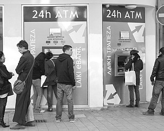 People wait to use the ATMs outside a Laiki Bank branch in Nicosia, Cyprus, on Sunday. Cyprus’ president said he is trying to amend a bailout plan that would tax all bank deposits.