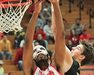 Youngstown State’s Damian Eargle (21) goes to the basket as Oakland’s Travis Bader (3) defends during a first-round CIT game Tuesday night at Beeghly Center. The Penguins won, 99-87.