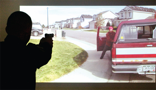 Hubbard Police Dept ptlm Brian Horne takes aim during a firearms training simualtion at the Police Dept Tuesday 3-19-13.