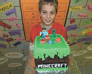 SPECIAL TO THE VINDICATOR
Second-grader Alex LaPlante shows his Minecraft cake that 
recently won top honors at Holy Family School’s cake walk 
during Catholic Schools Week. Alex is the son of John and Laurie LaPlante of Poland. Students and staff vote for their favorite cake and the top three cakes are recognized with prizes. During Family Fun Night, visitors and students play musical chairs to see who wins the cake of their choice until all the cakes are gone. This is the ninth year the school has sponsored the cake walk.
