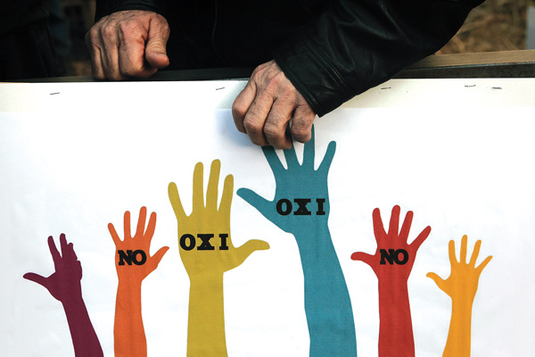 A protester holds a placard that reads “no” in Greek and English outside the European Union house during an anti-bailout demonstration in Nicosia, Cyprus, on Wednesday.