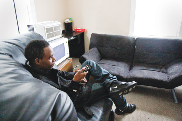 Jawan Johnson watches television in his Youngstown apartment. Johnson, 19, also has aged out of foster care and is living independently. He plans to attend Eastern Gateway Community College and YSU.