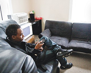Jawan Johnson watches television in his Youngstown apartment. Johnson, 19, also has aged out of foster care and is living independently. He plans to attend Eastern Gateway Community College and YSU.
