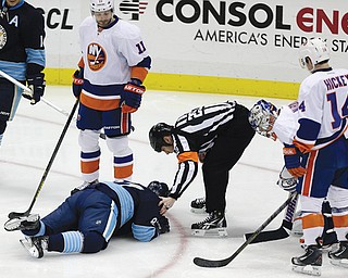 Pittsburgh Penguins center Sidney Crosby is helped by referee Ian Walsh after being hit in the face with a puck during the first period of a game against the New York Islanders in Pittsburgh on Saturday.