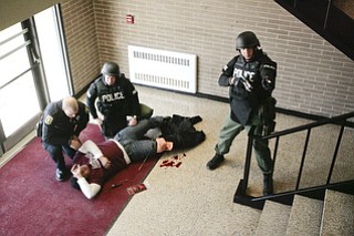 ROBERT K. YOSAY | THE VINDICATOR..Tending to an injured student (Braxton Menendez a junior at BHS )- Ptl Paul Poulis and Sgt Mike Huges - as Sgt Glen Riddle watches the staircaseBPD and area law enforcement had a mock drill of a shooter at Boardman High School - .. - -30-..