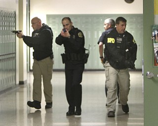 ROBERT K. YOSAY | THE VINDICATOR..Clearing a hallway Ptl Glen Patton - Ptl Rob Spector Det jack Neappolitan and Det Greg Stepak - a;ll BPD ..BPD and area law enforcement had a mock drill of a shooter at Boardman High School - .. - -30-..