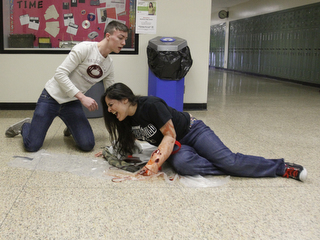            ROBERT K. YOSAY  | THE VINDICATOR..Juniors at BHS --  play the part of injured  student is Kaitlin McClendon  ( on the ground) as Cory Fowler comes to her aid..BPD and area law enforcement had a mock drill of a shooter at Boardman High School - .. - -30-..