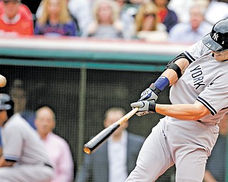 The New York Yankees’ Travis Hafner connects for a three-run home run off Cleveland starting pitcher Ubaldo Jimenez in the first inning of the Indians’ home opener Monday at Progressive Field. New York won 11-6, with Hafner, a former Indian, driving in four runs in his Cleveland homecoming.