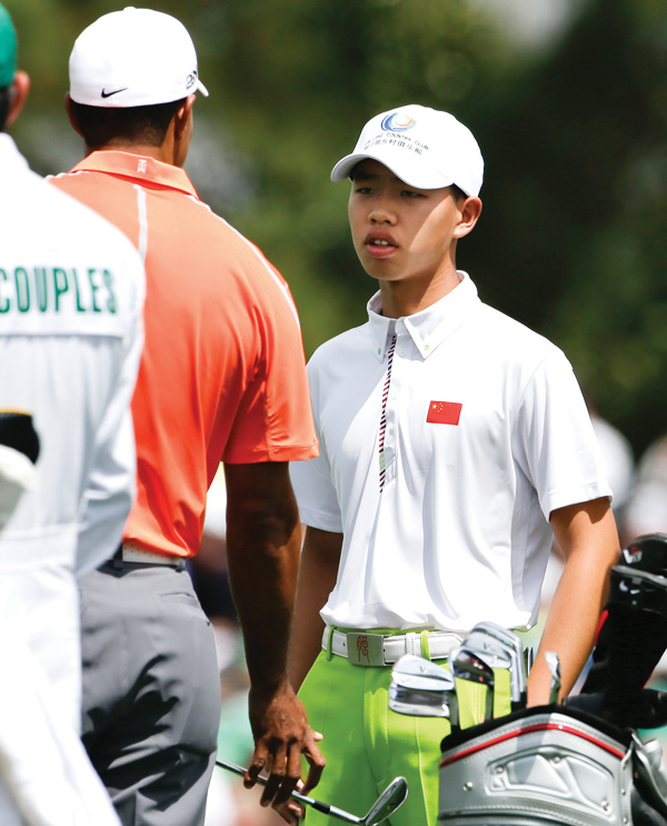 Golf prodigy Guan Tianlang, right, talks with Tiger Woods on the driving range during a practice round for the Masters on Monday in Augusta, Ga. The 14-year-old Tianlang of China is the youngest starter in U.S. Masters history.