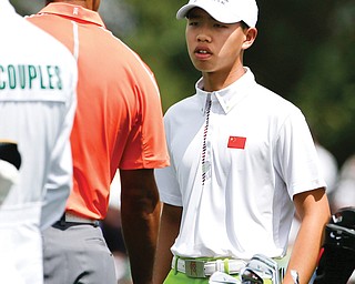 Golf prodigy Guan Tianlang, right, talks with Tiger Woods on the driving range during a practice round for the Masters on Monday in Augusta, Ga. The 14-year-old Tianlang of China is the youngest starter in U.S. Masters history.