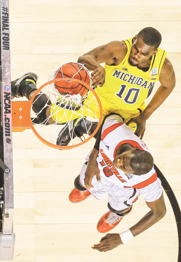 Michigan guard Tim Hardaway Jr. (10) dunks over Louisville center Gorgui Dieng (10) during the second half of the men’s NCAA championship Monday in Atlanta. The No. 1-seeded Cardinals soared to an 82-76 victory over the No. 4-seeded Wolverines.