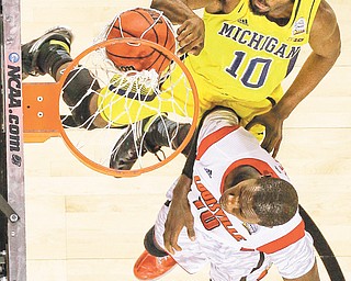 Michigan guard Tim Hardaway Jr. (10) dunks over Louisville center Gorgui Dieng (10) during the second half of the men’s NCAA championship Monday in Atlanta. The No. 1-seeded Cardinals soared to an 82-76 victory over the No. 4-seeded Wolverines.