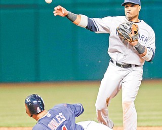 New York Yankees’ Robinson Cano, right, throws to first base for the final out of the game after getting Cleveland
Indians’ Mike Aviles out at second base in the ninth inning Tuesday in Cleveland.