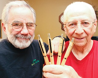 Austintown Fitch High School 1962 graduates Larry Cadman, left, and Jack Kidd display ink pens made of wood from the old Fitch High School gym floor. The pens are being used to raise money for a memorial to two Class of 1962 graduates who were killed in the Vietnam War.