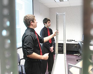 Youngstown State University engineering students Brandon O’Neill, left, of Lordstown, and Kyle Spickler of Columbiana, show scaffolding they designed as part of a contest with Hynes Industries of Austintown.