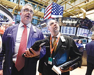 Traders Kenneth Polcari, left, and John Liotti work on the floor of the New York Stock Exchange. They were at work Friday.