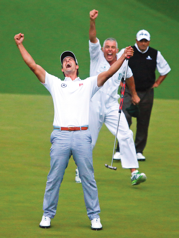 Adam Scott and his caddie Steve Williams celebrate after Scott’s putt dropped into the cup on the second hole of the playoff to win the Masters on Sunday in Augusta. Scott bested Argentine golfer Angel Cabrera, background, to become the first Australian to win the tournament.