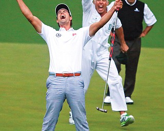 Adam Scott and his caddie Steve Williams celebrate after Scott’s putt dropped into the cup on the second hole of the playoff to win the Masters on Sunday in Augusta. Scott bested Argentine golfer Angel Cabrera, background, to become the first Australian to win the tournament.